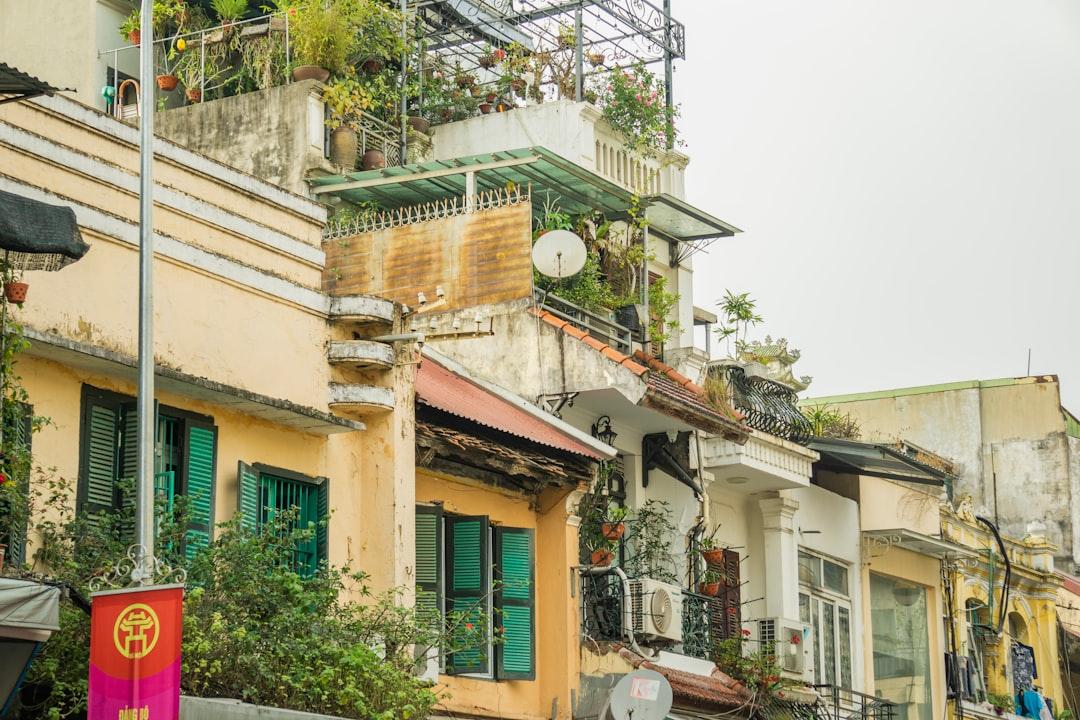 A row of buildings with balconies and green shutters from Phong Phạm on Unsplash