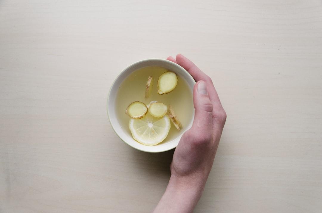 Person holding white bowl with sliced lime and ginger inside from Dominik Martin on Unsplash