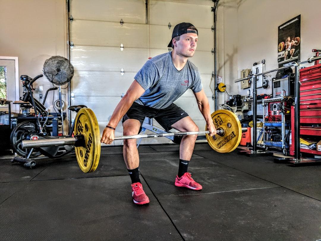 Man carrying yellow barbell from Sam Sabourin on Unsplash