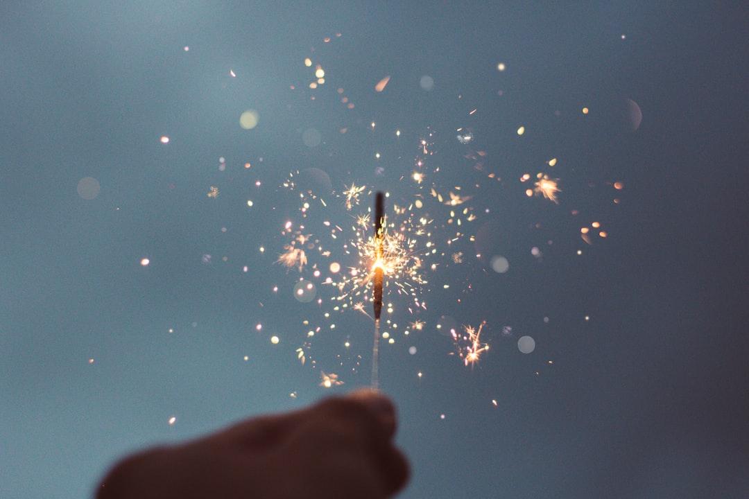 Person holding lighted sparklers from Cristian Escobar on Unsplash