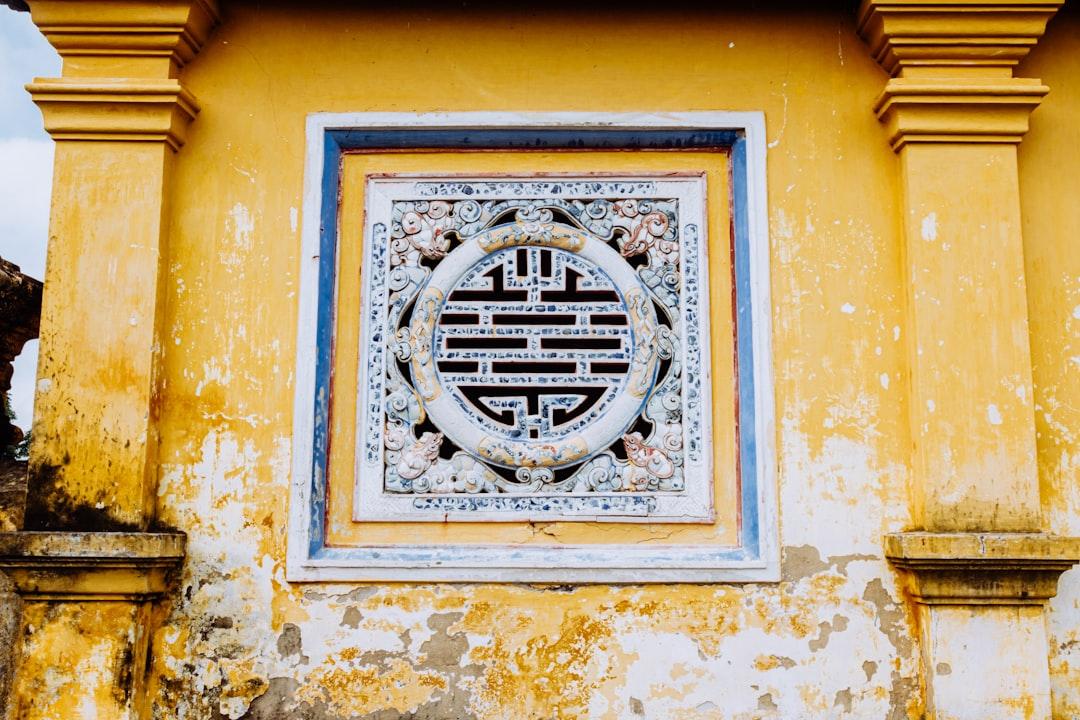 Ornate window in a yellow, aged wall. from Daniele Franchi on Unsplash