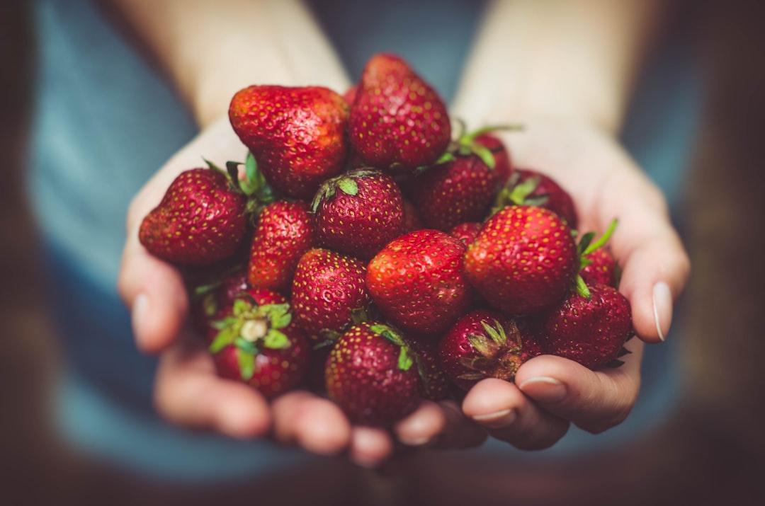 Shallow focus photography of strawberries on person's palm from Arturrro on Unsplash Tủ lạnh ngày Tết