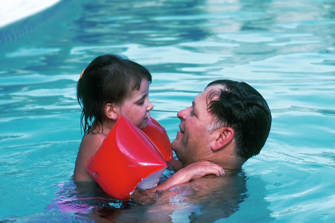 Man with toddler girl in swimming pool from National Cancer Institute on Unsplash