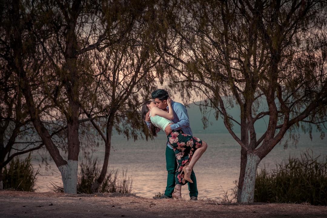 Couple kissing in front of trees from Danie Franco on Unsplash