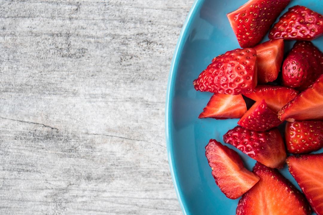 Sliced strawberries on teal ceramic plate from Jessica Lewis 🦋 thepaintedsquare on Unsplash Thức ăn tốt cho bệnh nhân tim