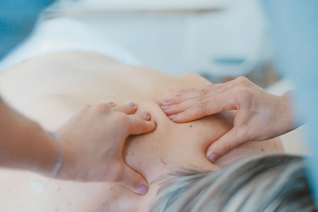 Person massaging the back of a woman from Toa Heftiba on Unsplash