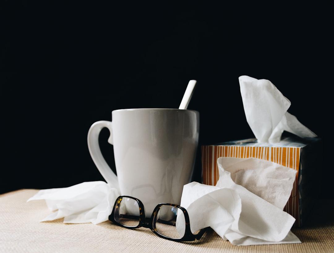 White ceramic mug on white table beside black eyeglasses from Kelly Sikkema on Unsplash