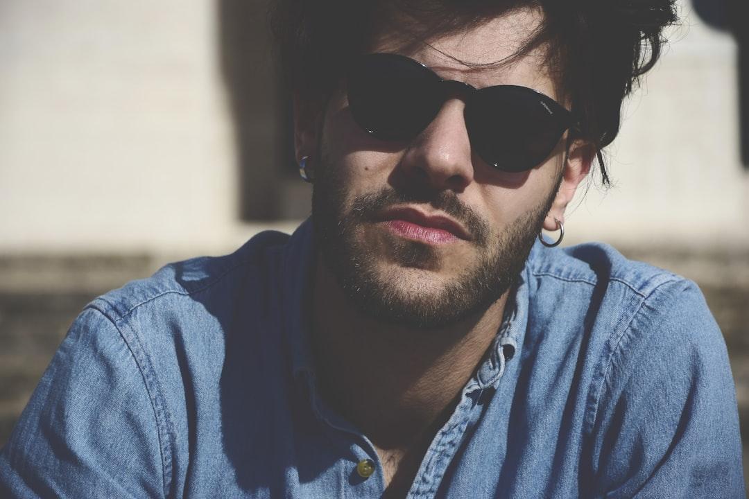 Man wearing blue denim top and black sunglasses from Andrea Dibitonto on Unsplash Vô sinh nam liên quan tới ung thư tuyến tiền liệt