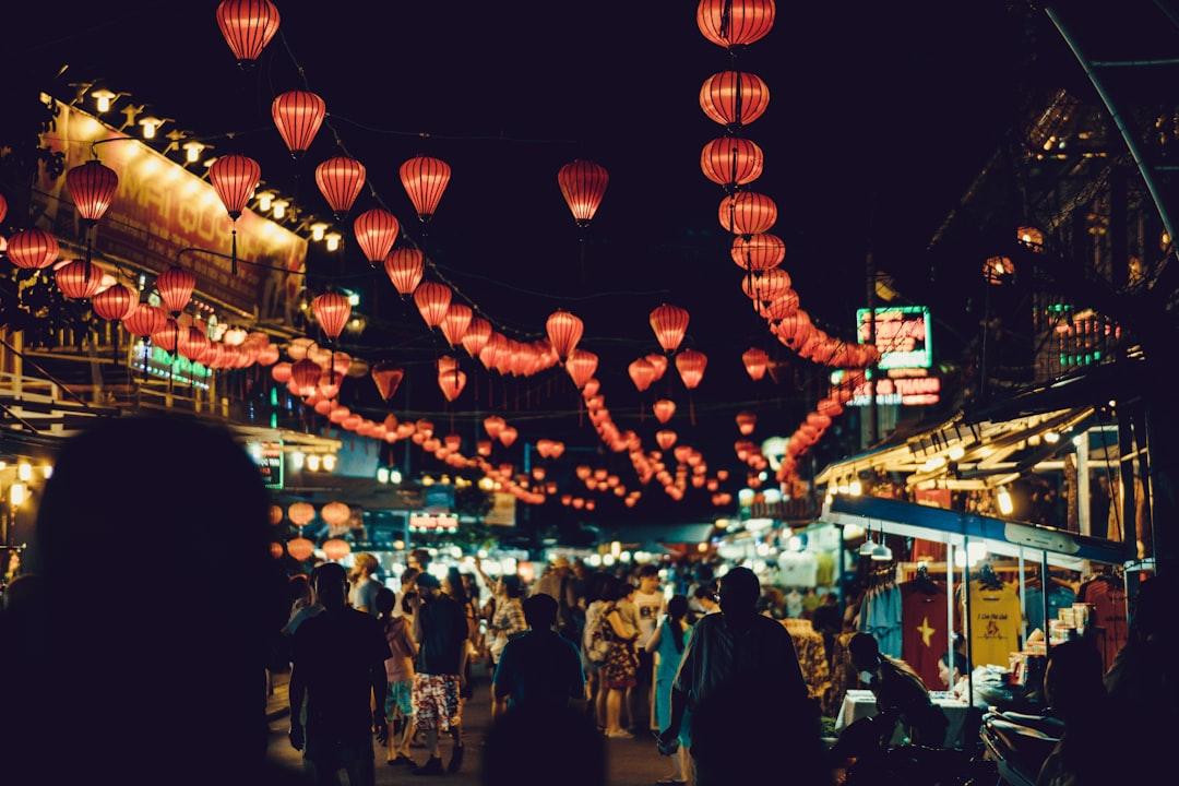 People walking between food stalls under chinese lanterns from Chris Slupski on Unsplash
