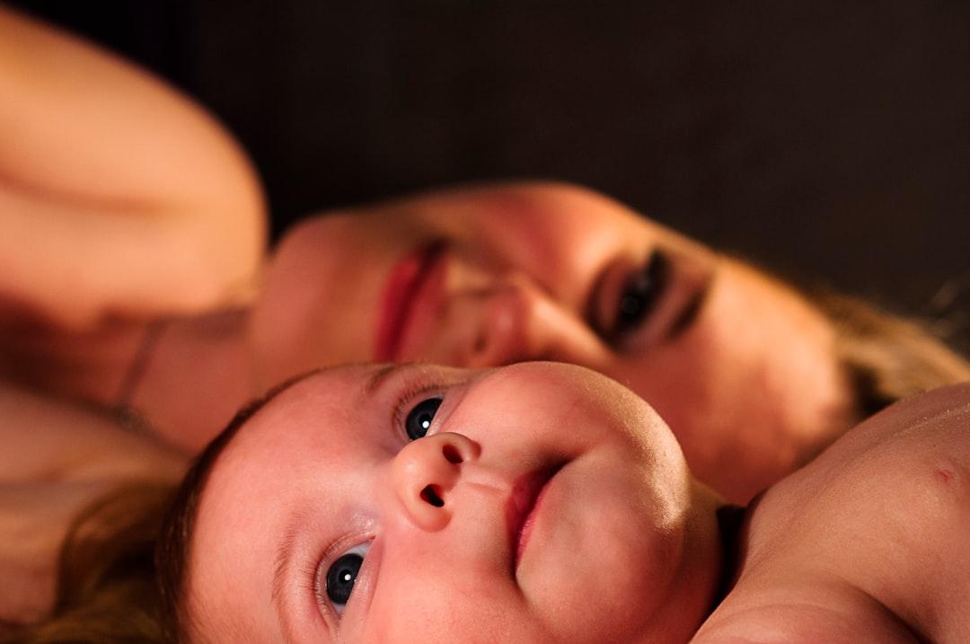 Shallow focus photography of baby beside woman from Oleg Sergeichik on Unsplash