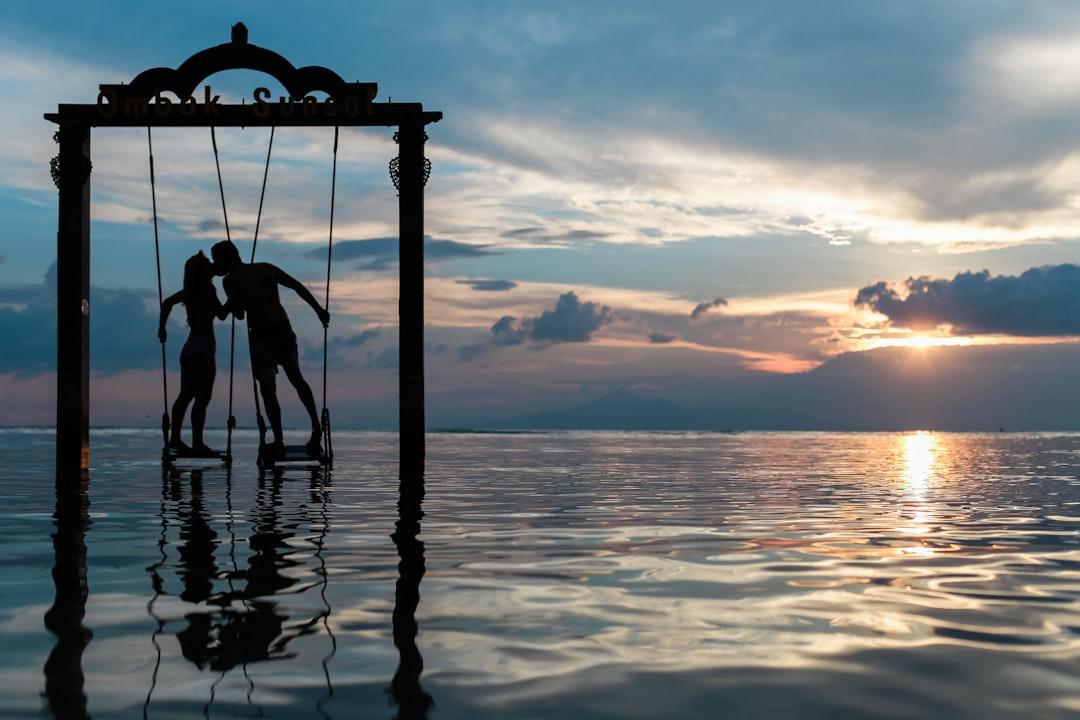 A couple standing in the sea while kissing from Azrul Aziz on Unsplash