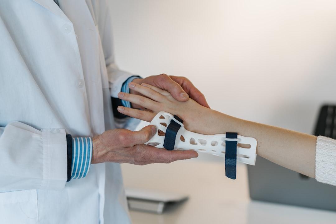 Person in white coat holding silver and blue ring from Tom Claes on Unsplash