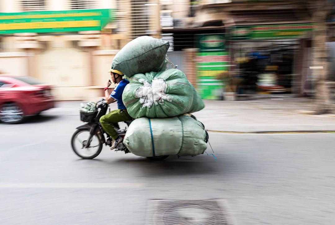 A person riding a bike with a large bag on the back of it from Tristan Ruark on Unsplash