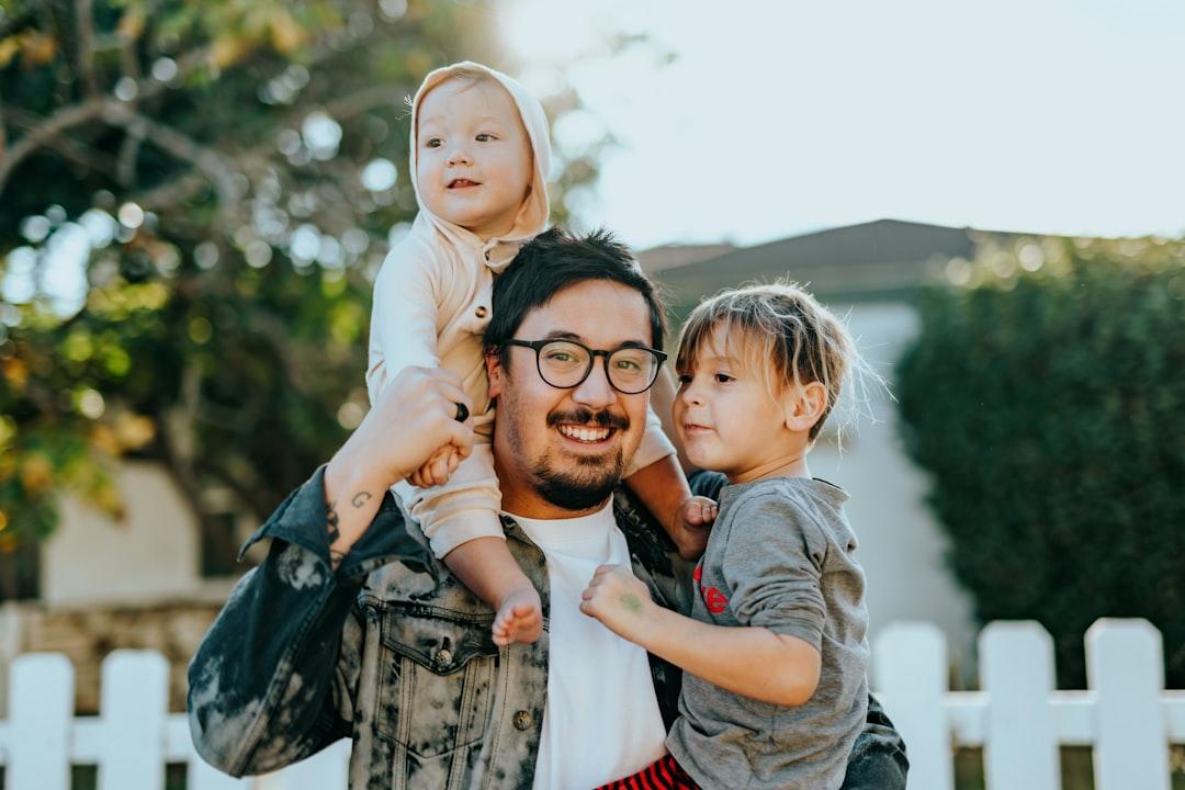 Man in white shirt carrying girl in gray shirt from Nathan Dumlao on Unsplash