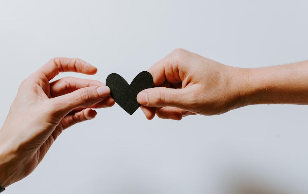 Two person holding papercut heart from Kelly Sikkema on Unsplash