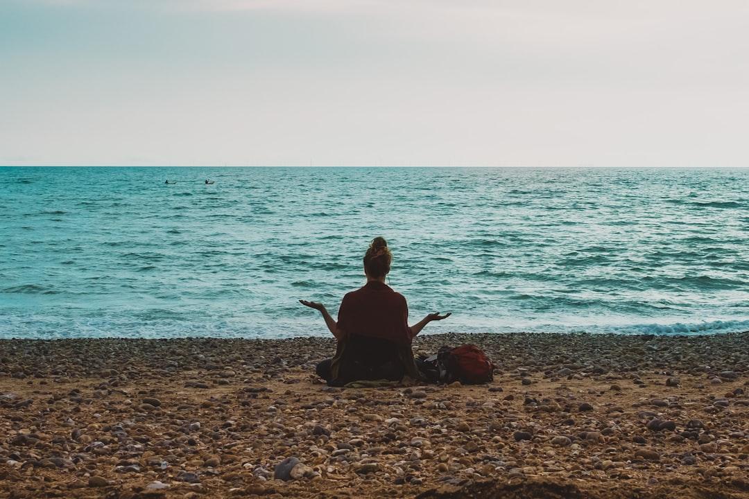 Person doing yoga on seashore during daytime from processingly on Unsplash