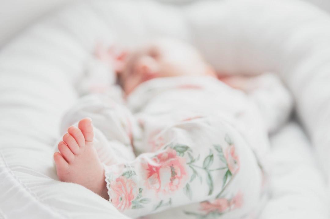 Baby in white and red floral onesie lying on bed from Tuva Mathilde Løland on Unsplash Ngộ độc thuốc ngủ