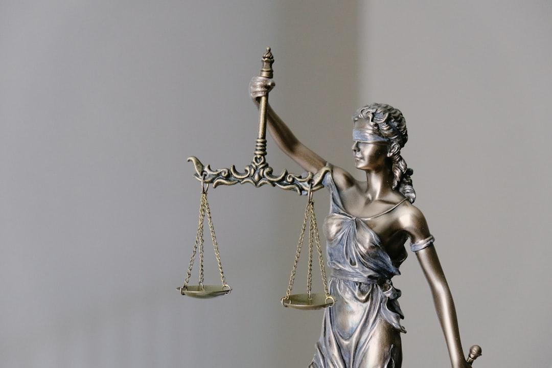 Woman in dress holding sword figurine from Tingey Injury Law Firm on Unsplash