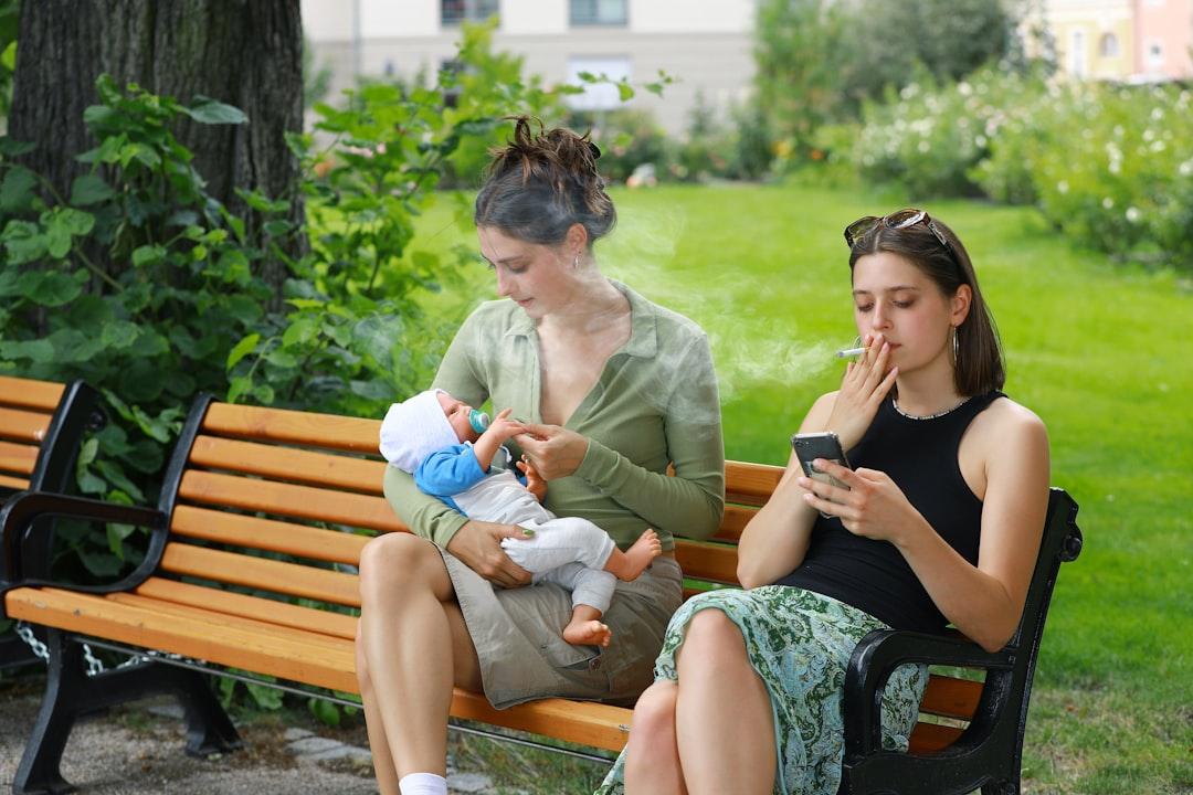 Two women sitting on a bench with a baby from Ernst-Günther Krause (NID) on Unsplash