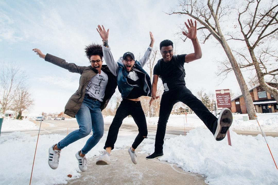 Photo of three men jumping on ground near bare trees during daytime from Zachary Nelson on Unsplash