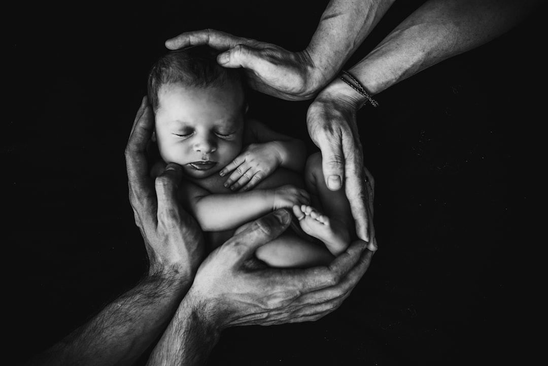 grayscale photo of woman hugging baby Đầu - Bé rụng tóc hoặc không có tóc