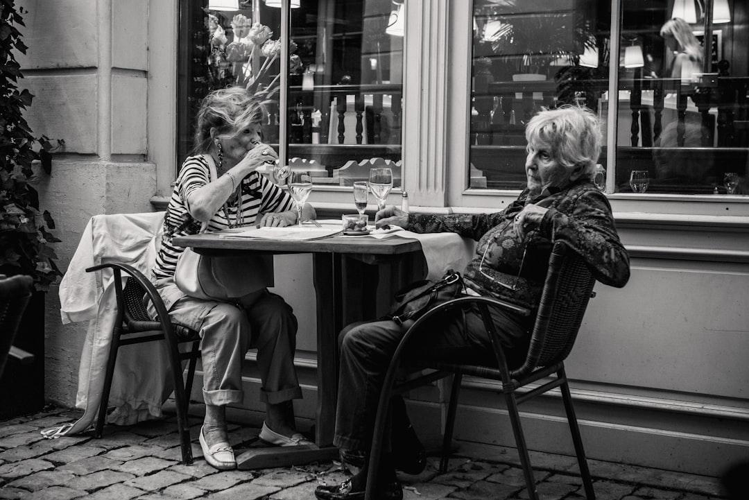 Grayscale photo of two woman sitting beside the table from Jez Timms on Unsplash ĐBSCL: Tỷ lệ nữ nhiễm HIV cao nhất nước