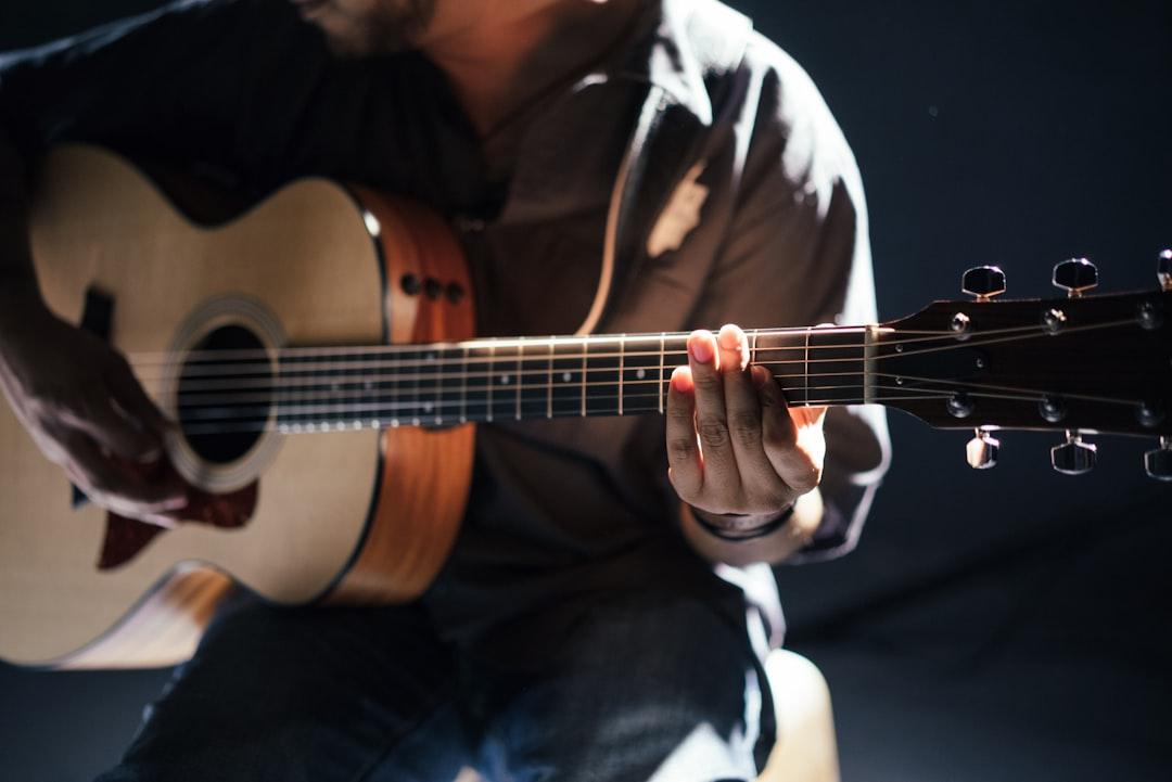 Person playing guitar from Gabriel Gurrola on Unsplash Cải thiện chứng ù tai bằng âm nhạc