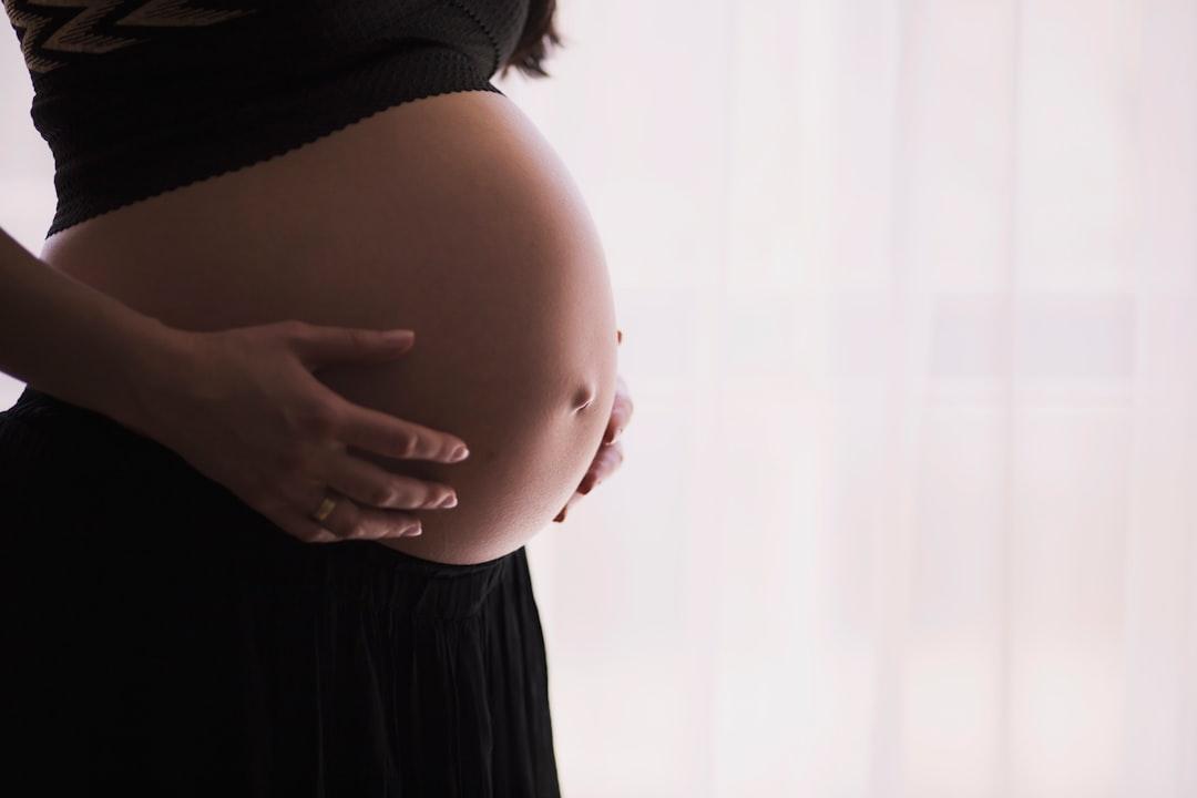 Woman holding stomach from freestocks on Unsplash Cứu sống mẹ con thai phụ mắc cúm A/H1N1 nặng