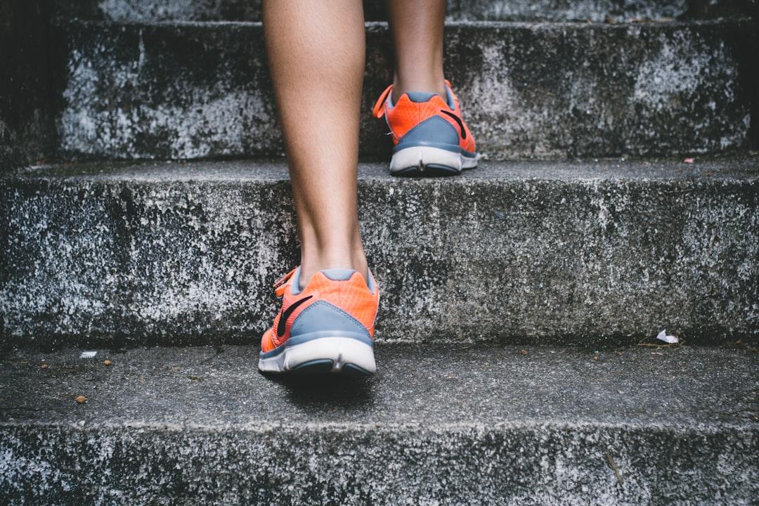 Person wearing orange and gray nike shoes walking on gray concrete stairs from Bruno Nascimento on Unsplash Gặp “hên” khi tìm đúng phương pháp cho bệnh lạc nội mạc tử cung