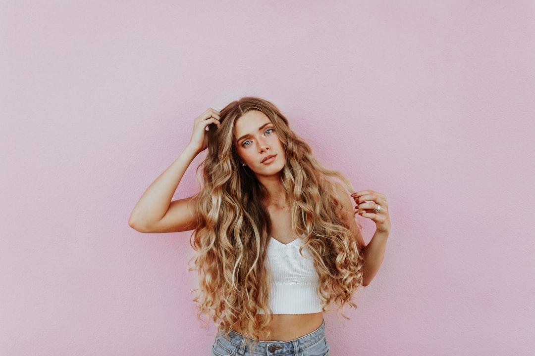 Woman standing next to pink wall while scratching her head from averie woodard on Unsplash Vì sao bạn nên chọn thực phẩm ngũ cốc nguyên cám