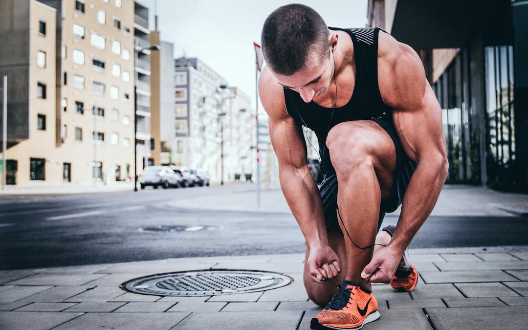 Man tying his shoes from Alexander Red on Unsplash