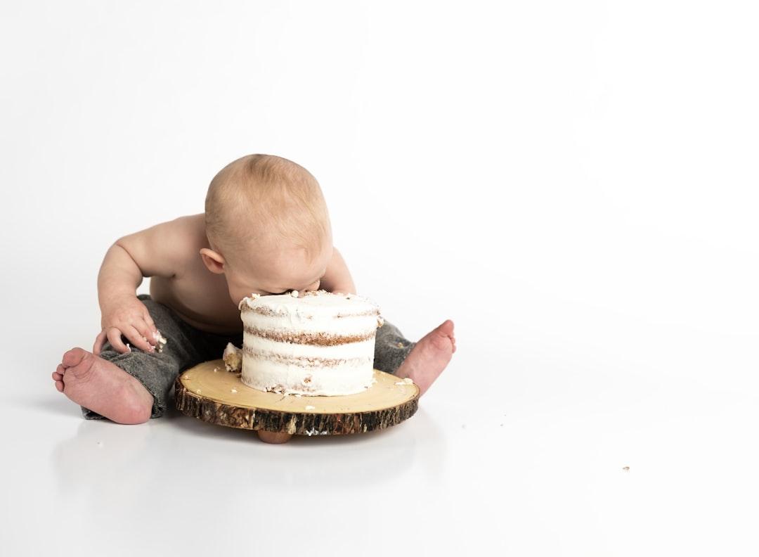 Kid sitting beside round cake close-up photography from Henley Design Studio on Unsplash