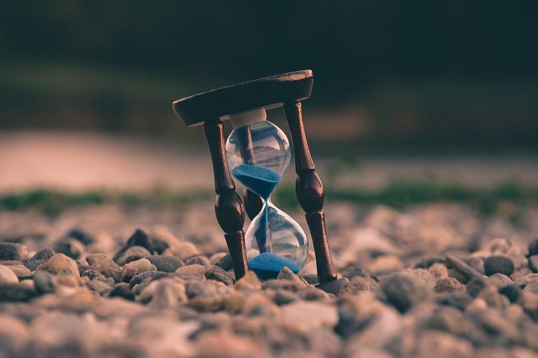 Selective focus photo of brown and blue hourglass on stones from Aron Visuals on Unsplash Ăn trưa muộn dễ béo phì