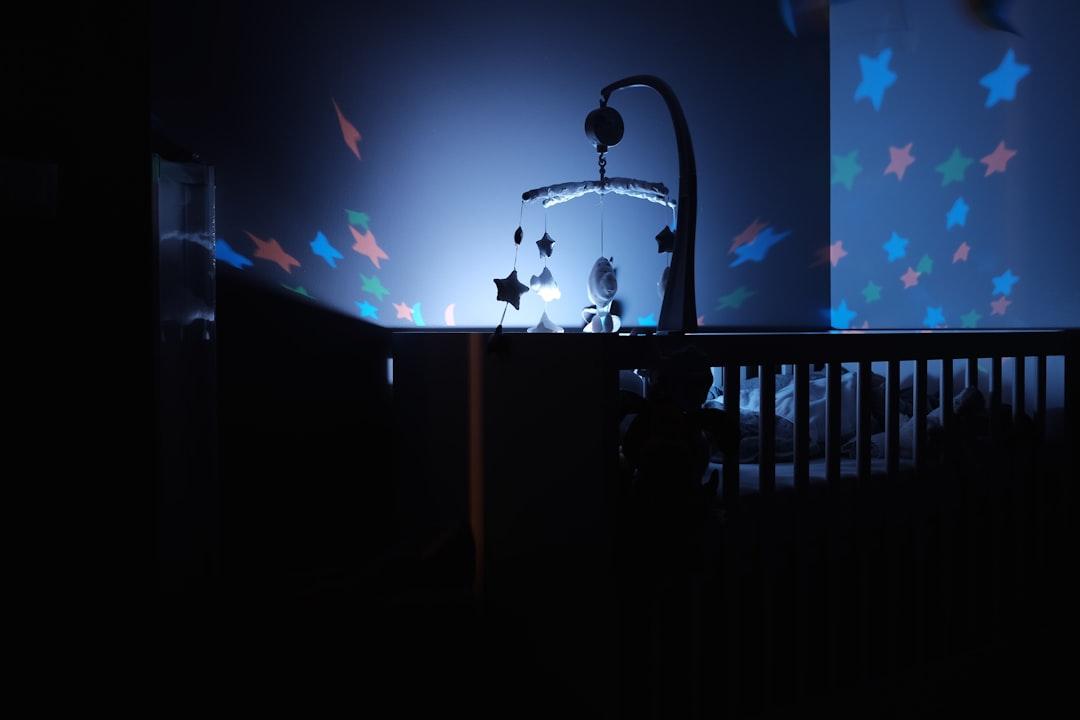 Baby's black wooden crib with led crib mobile from Bastien Jaillot on Unsplash