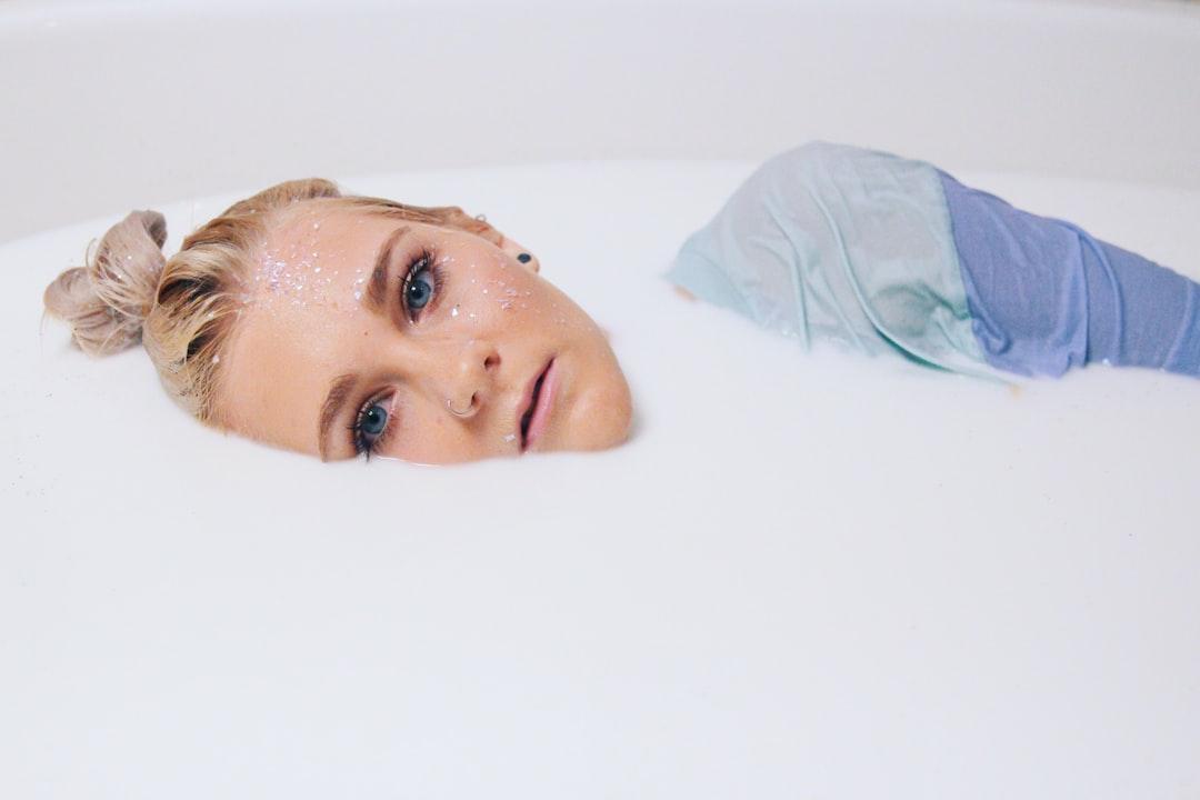 Blonde hair woman in blue top on white liquid from averie woodard on Unsplash