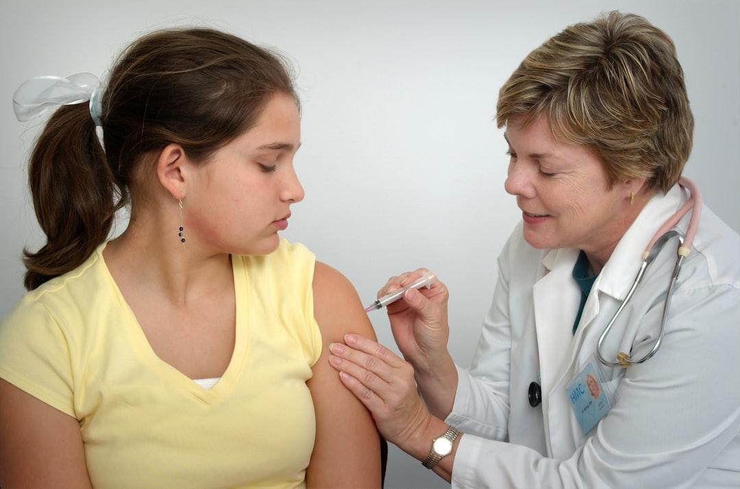 Woman injecting girl's left arm from CDC on Unsplash